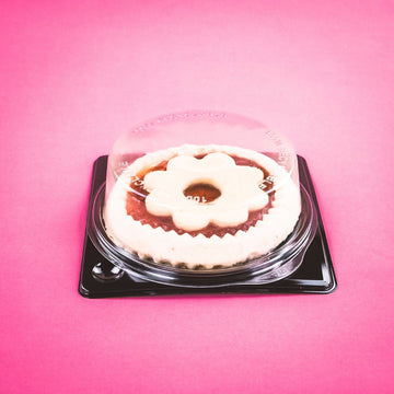 Vassoio nero con coperchio trasparente con dentro torta
